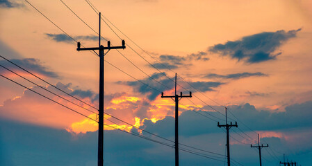 Silhouette electricity post at sunset background.