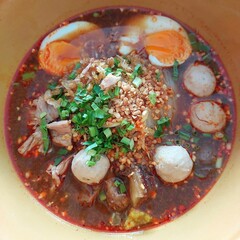 Delicious Spicy Thai Noodle Soup with Meatballs Eggs and Herbs