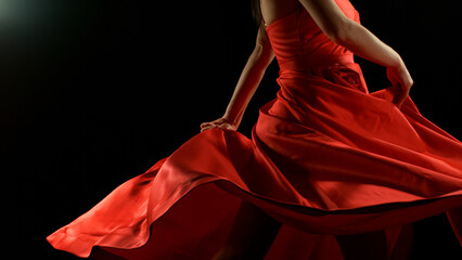 Brunette Woman in Ruby Red Dress Dancing Against a Black Background , Freeze Motion