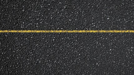 Fototapeta premium Yellow line on asphalt road surface capturing urban transportation concept