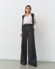 Elegant woman poses confidently in stylish outfit inside modern studio setting