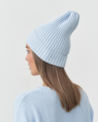 Elegance in soft hues as a model poses in a stylish beanie and sweater