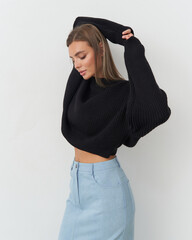 Beautiful model showcasing fashionable knitwear in a stylish studio setting