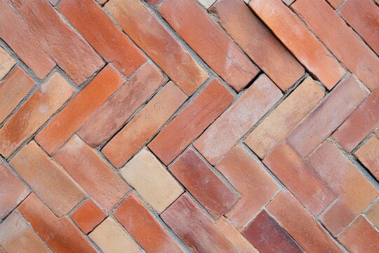 Fototapeta Intricate herringbone pattern of terracotta bricks on the outdoor pathway showcasing craftsmanship and design