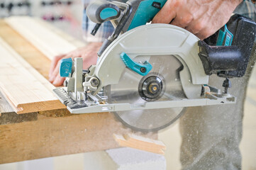 A skilled craftsman operates a circular saw on a wooden plank, showcasing precision and...