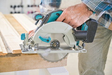 A skilled craftsman operates a circular saw on a wooden plank, showcasing precision and...