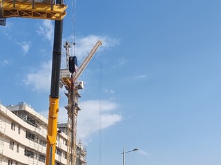 Yellow Color Fixed Crane Erected Beside Under Construction Residential Building.
Highrise Portable...