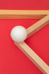 Still life with wooden blocks and a a plastic foam ball on red background	