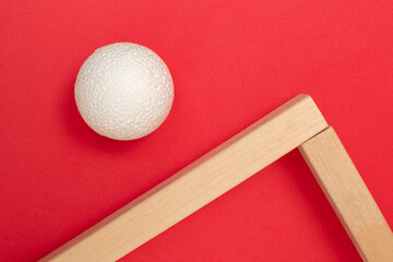 Still life with wooden blocks and a a plastic foam ball on red background	