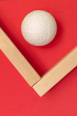 Still life with wooden blocks and a a plastic foam ball on red background	