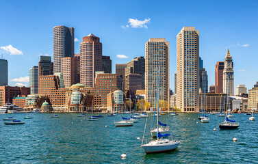 A vibrant daytime view of Boston’s downtown skyline featuring marina with boats, modern skyscrapers, and historic architecture