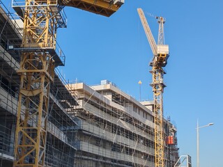 Yellow Color Fixed Crane Erected Beside Under Construction Residential Building.
Highrise Portable...