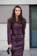 Modern feminine outfit with high-quality burgundy leather skirt and structured jacket styled for...