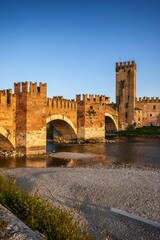 Fototapeta premium Sunlit view of the historic Castelvecchio Bridge in Verona.
