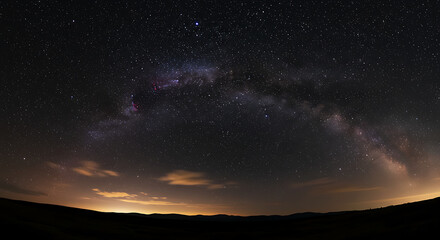 Fototapeta premium A view of the night sky with stars and clouds over a dark horizon landscape view