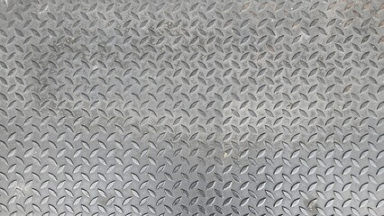 Old silver steel floor with stains. Steel floor with caterpillar pattern. Texture and background image. Steel plate with cross-hatch non-slip texture pattern.