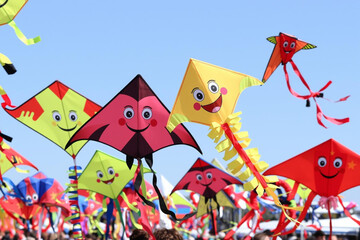 Fototapeta premium Vibrant Kite Festival Delights with Smiling Faces and Colorful Designs in Clear Blue Skies