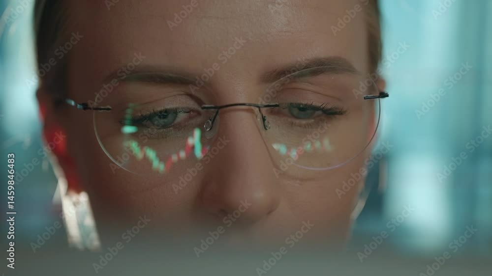 Poster trader wearing glasses is working on laptop computer. screen with stock market charts and bitcoin bt