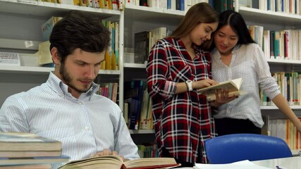 Focused male student engrossed in reading at the library