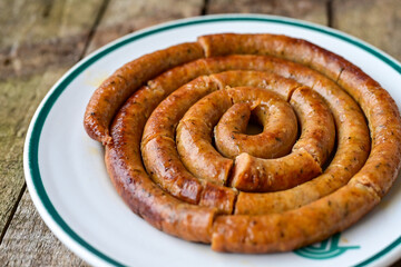 Grilled  pork  juicy sausages on wooden board outdoors. Grilling food, bbq, barbecue, picnic
