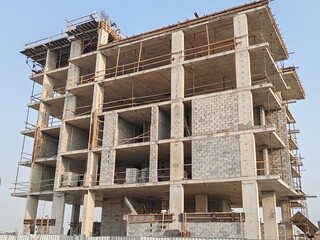 Under construction residential building structure
Highrise Tower Exterior Modern Design Top Level View with blue sky background.
Multi Story Residential Building Site with erected Scaffolding Around