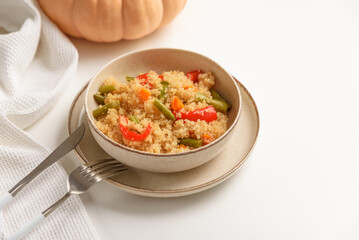Quinoa vegetable salad on white wooden table. Vegetarian and diet food