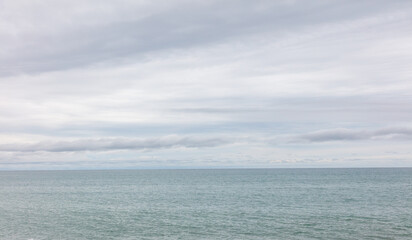 Obraz premium The sky is cloudy and the ocean is calm