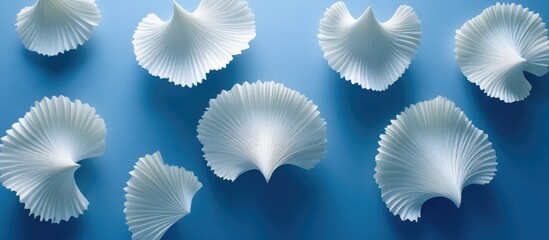 Abstract design of sculpted, pleated, white forms on a blue background.  Complex, delicate, layered shapes resembling stylized leaves or petals
