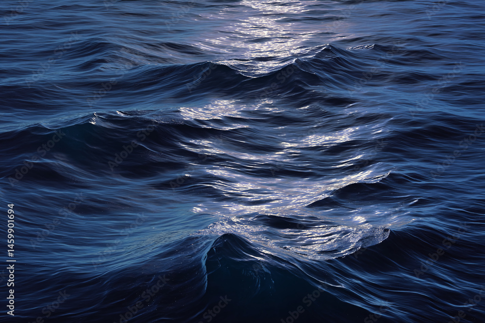 Poster dark blue ocean waves texture, showing ripple pattern and light reflection, conveying calmness and s