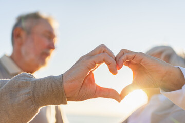 Love heart shape peace. Senior older couple making heart shape with their hands. Adult mature old...