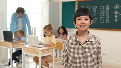 Skilled asian boy looking and waving hands while friend studying about writing engineering code or...