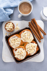 Cinnamon rolls topped with cream cheese frosting and sliced almonds