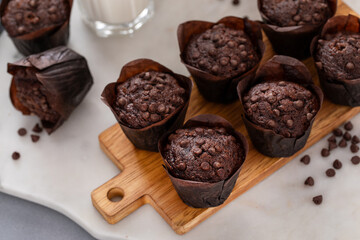 Chocolate chip muffins on a board served with milk
