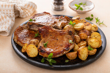 Pork chops on a bone grilled or sauteed served with roasted potatoes