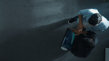 Top down view of manager walking to investor while holding tablet and looking at financial...