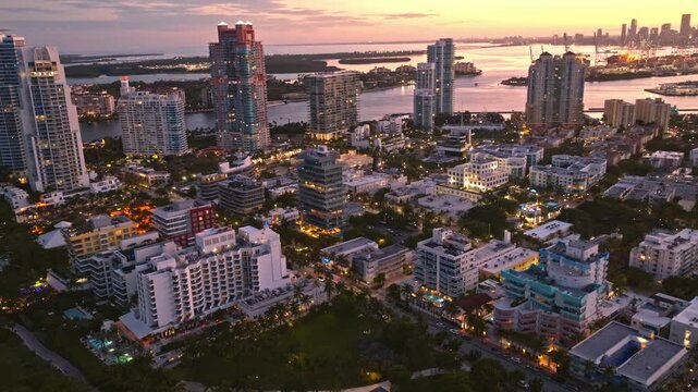 Drone view Miami city at night with dramatic sky. Miami city seaside at dusk. Aerial view of evening Miami and cityscape. Coastline of Miami city, night shot. American city.