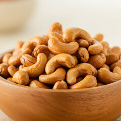 Fototapeta premium A close up shot of a wooden bowl filled to the brim with roasted and salted cashew nuts snack