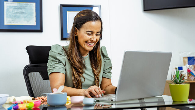 Smiling Nutritionist Working at Desk in Bright Office Setting