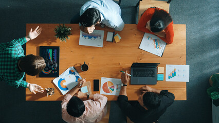 Top down view of manager holds tablet display increasing sales and placed on meeting table. Group of diverse business team clapping hands to celebrate successful product at meeting room Convocation.