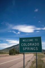 Welcome to Colorado Springs Road Sign on a Sunny Day - Travel Destination, Mountain Views, and Clear Blue Skies