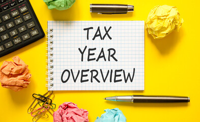 Tax year overview symbol. Concept words Tax year overview on beautiful white note. Beautiful yellow background. Black pen. Black calculator. Business tax year overview concept. Copy space.