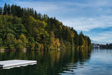 Obraz premium Lake Bled, Slovenia - October 18, 2021: A long distance view of Bled Island in Autumn, amid a green and blue natural landscape