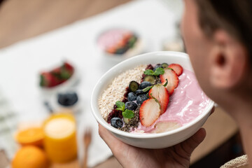 Focused photo on healthy food yogurt toppings with berry fruit in smart broadcaster tasting blurred...
