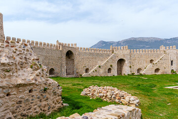 Historic Stone Fortress Amidst Stunning Mountain Landscape on a Sunny Day..