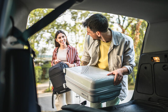 man and women couple pack luggage baggage in trunk of the car