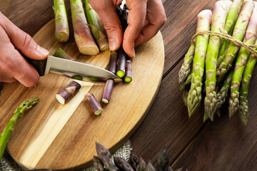 Preparing fresh asparagus for cooking in a rustic kitchen setting