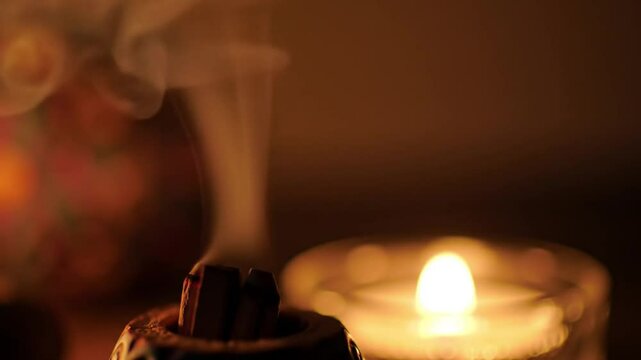 Palo Santo burning with candle in background