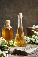 Hawthorn flower tincture in a glass bottle in spring