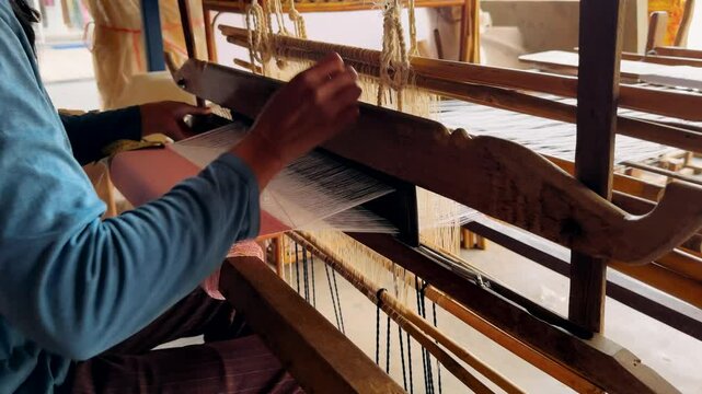 Silk farm. Woman weaving on a traditional loom. Traditional cotton hand weaving.

