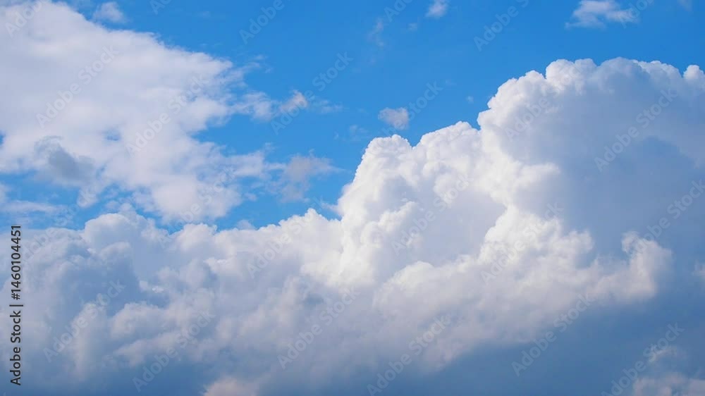 Poster Time - lapse during a serene evening, fluffy clouds leisurely float across the vibrant blue sky, illuminated by the warm glow of the setting sun, evoking a sense of wonder and tranquility